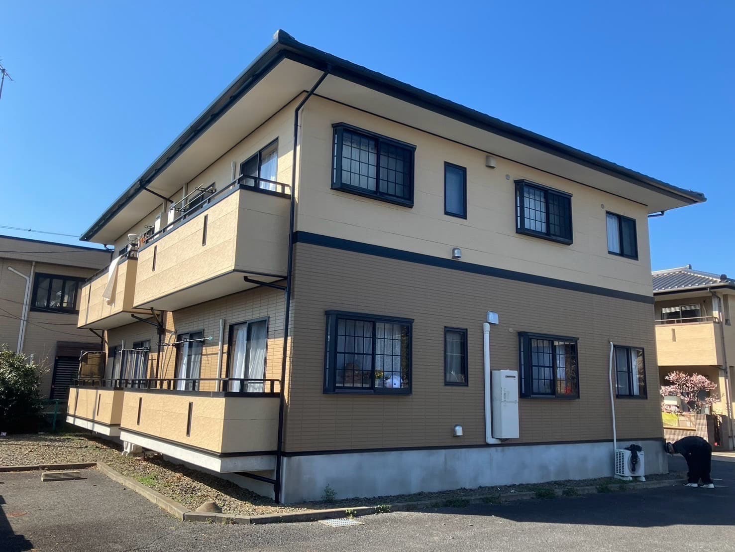 外壁をベージュとサンドベージュに塗装された賃貸物件